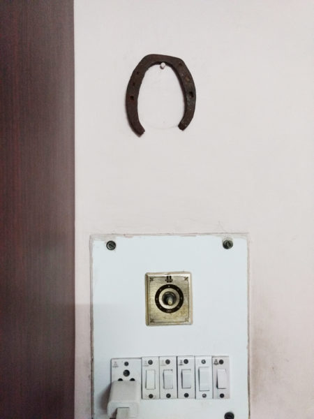 The horseshoe hanging on the wall of the family's puja room.