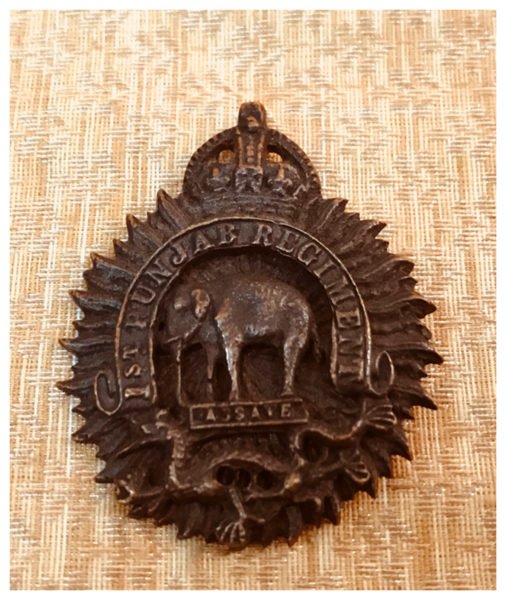 Badge of 1st Punjab Regiment 1922-56 belonging to Sepoy Amar Singh, with three main elements : The British Crown, an Elephant, indicating the battle of Assaye, and a Dragon, indicating the victory of British in the First Opium War.